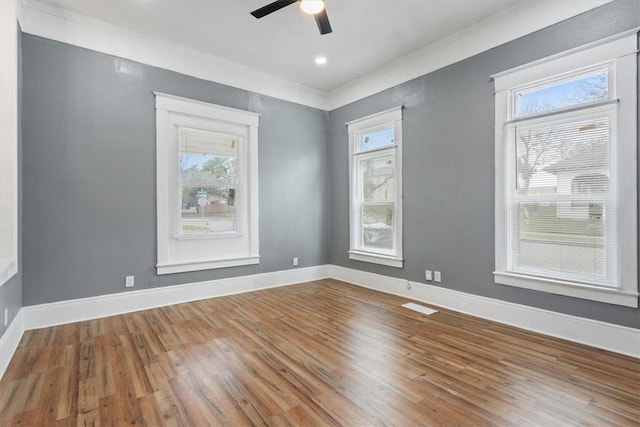 unfurnished room with ceiling fan, ornamental molding, wood finished floors, and plenty of natural light