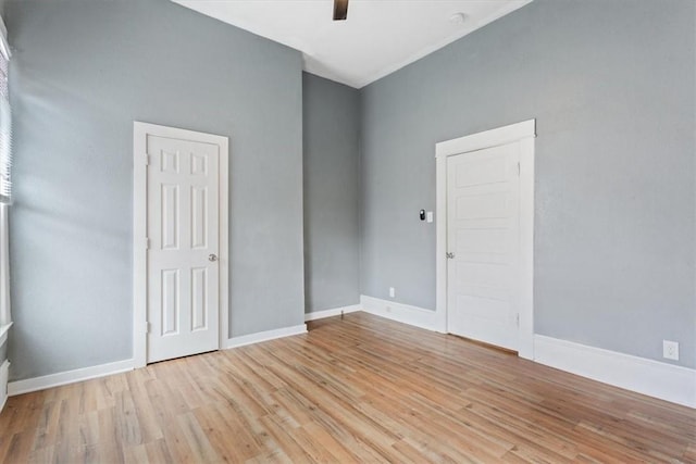 unfurnished room featuring baseboards and light wood-type flooring