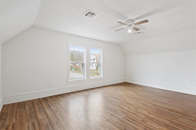 bonus room with lofted ceiling, a ceiling fan, visible vents, and wood finished floors