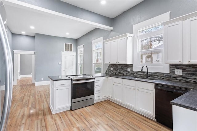 kitchen with a peninsula, a sink, tasteful backsplash, visible vents, and appliances with stainless steel finishes