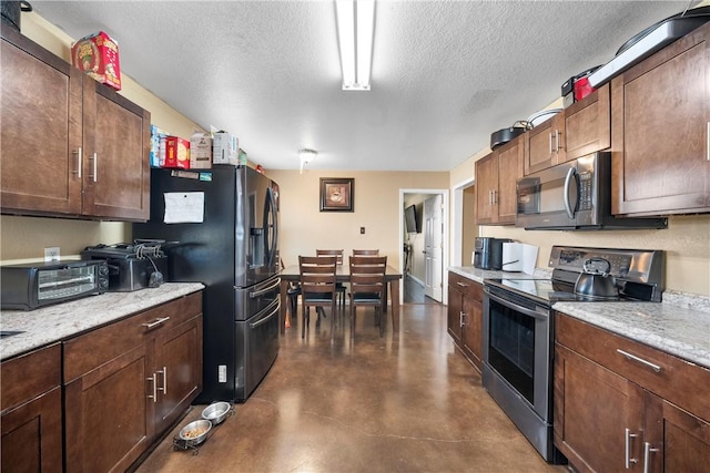 101 Hassie Ln, Waco, TX 76705 - kitchen featuring stainless steel appliances, a textured ceiling, concrete flooring, and light stone countertops
