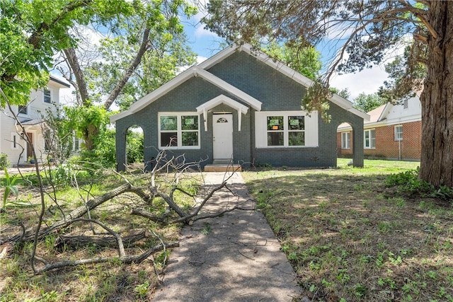 craftsman-style house with brick siding and a front yard