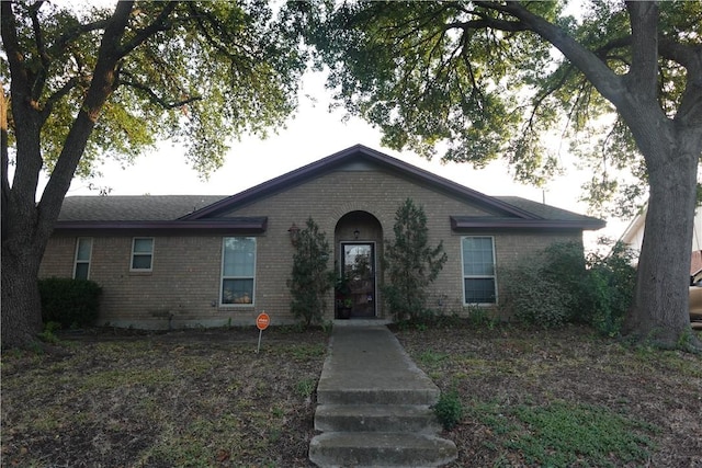 single story home featuring brick siding