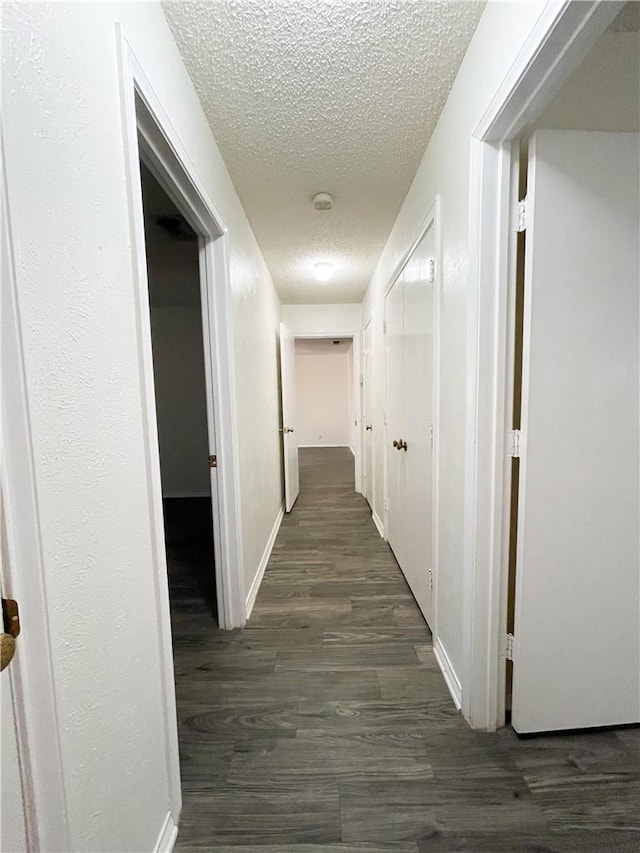 5004 Lakeshore Dr, Waco, TX 76710 - hall with dark wood-style floors, a textured ceiling, and baseboards