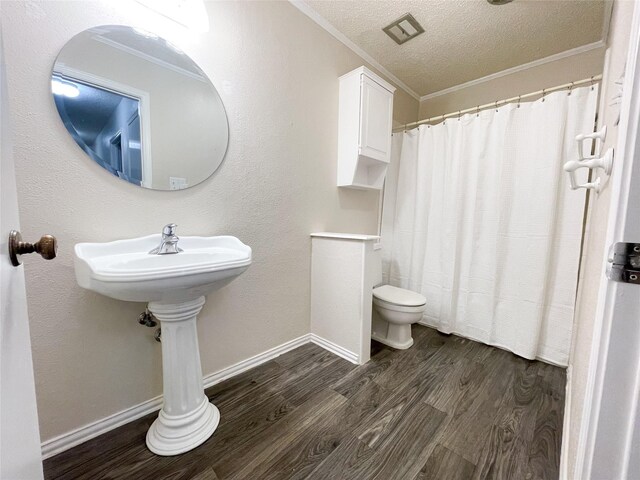5004 Lakeshore Dr, Waco, TX 76710 - bathroom with ornamental molding, toilet, wood finished floors, and a textured ceiling