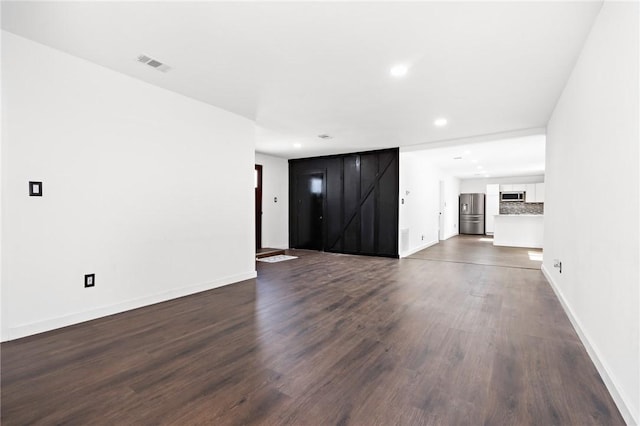 3212 Robinson Rd, Waco, TX 76706 - unfurnished living room with dark wood-type flooring, baseboards, and visible vents