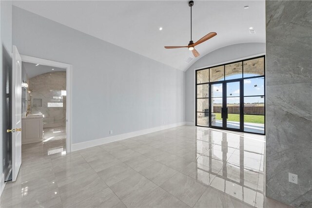 spare room featuring vaulted ceiling, baseboards, and ceiling fan