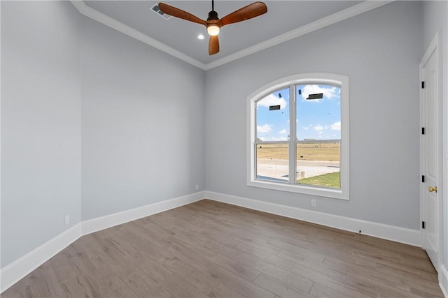 unfurnished room with visible vents, crown molding, ceiling fan, baseboards, and wood finished floors