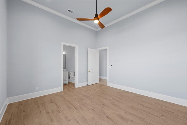 unfurnished bedroom featuring visible vents, light wood-style flooring, ensuite bath, crown molding, and baseboards