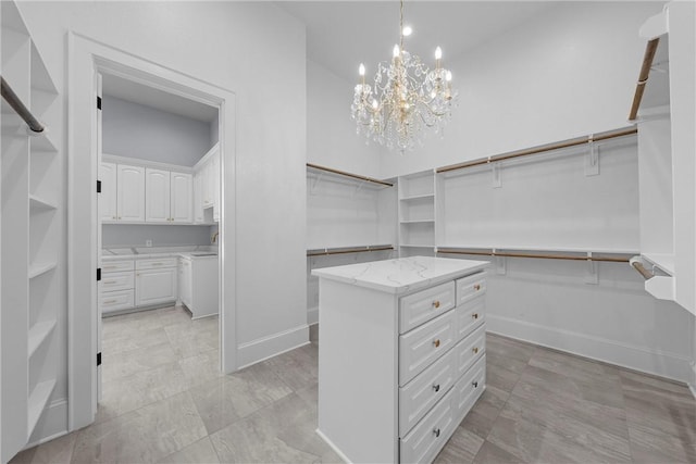 walk in closet with a chandelier and a towering ceiling