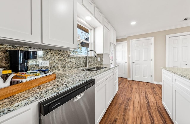 kitchen featuring dishwasher, ornamental molding, decorative backsplash, white cabinetry, and a sink