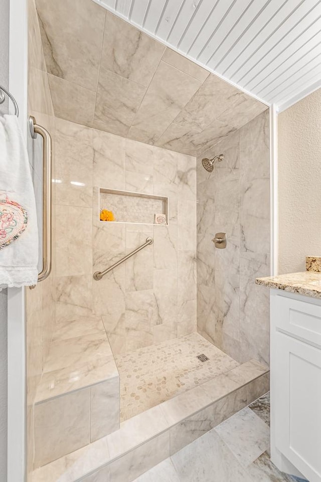 bathroom with vanity and a tile shower