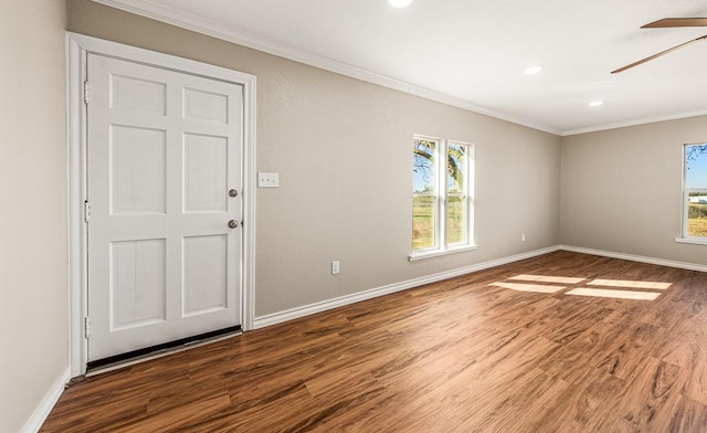 unfurnished room with a ceiling fan, wood finished floors, baseboards, and ornamental molding