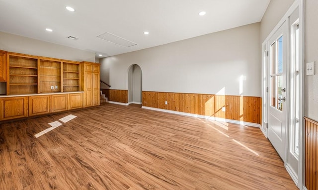 spare room featuring visible vents, a wainscoted wall, light wood finished floors, recessed lighting, and arched walkways
