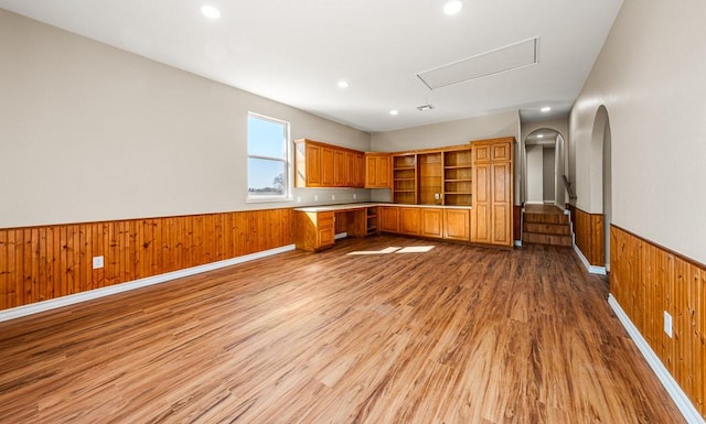 kitchen with a wainscoted wall, brown cabinets, open shelves, wood walls, and light wood finished floors