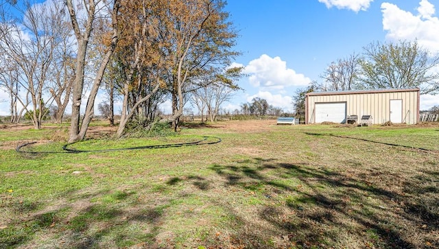 view of yard featuring a detached garage and an outdoor structure