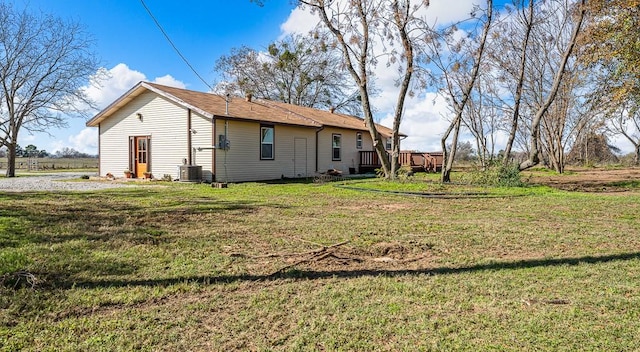 back of house with cooling unit and a yard