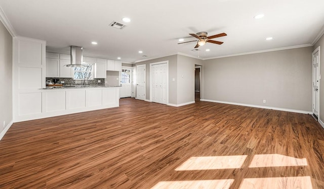 unfurnished living room featuring visible vents, wood finished floors, crown molding, baseboards, and ceiling fan