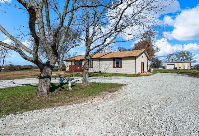 ranch-style home featuring an outbuilding and driveway