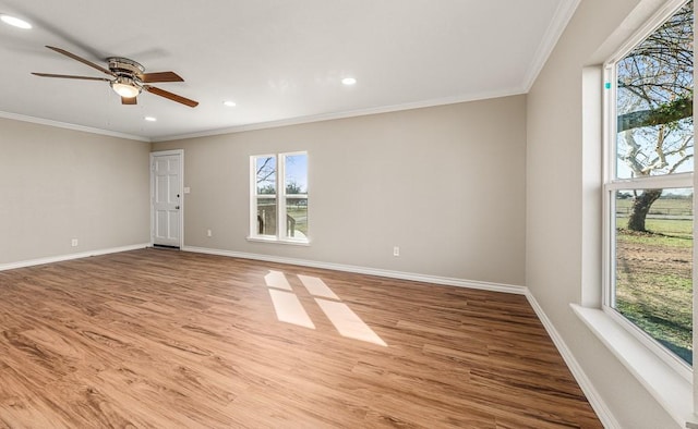 empty room featuring ornamental molding, baseboards, ceiling fan, and wood finished floors