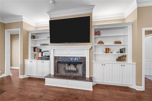 living room with crown molding, baseboards, built in shelves, dark wood-style floors, and a high end fireplace