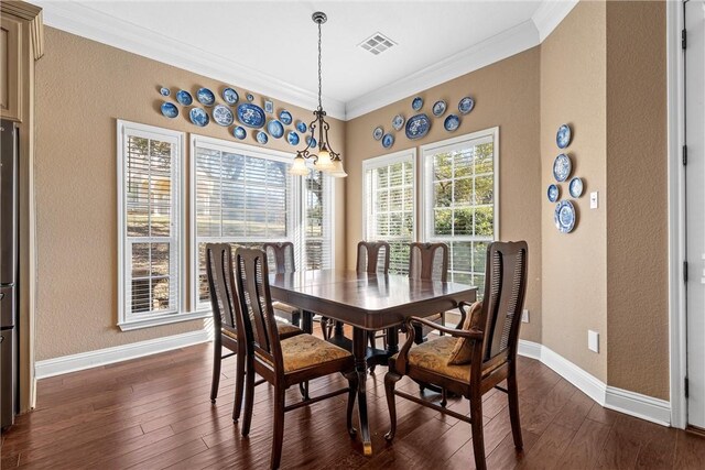 dining room featuring baseboards, dark wood-style flooring, ornamental molding, and visible vents