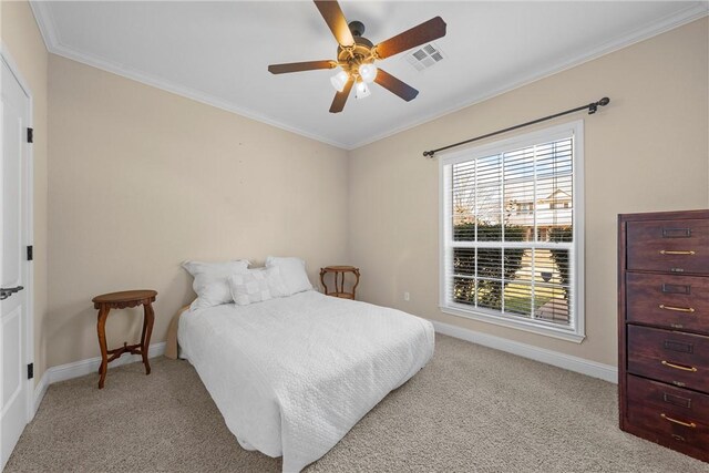 bedroom featuring crown molding, baseboards, visible vents, ceiling fan, and carpet