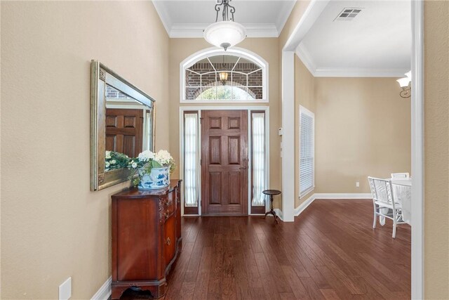 entrance foyer featuring baseboards, dark wood-style flooring, ornamental molding, and visible vents