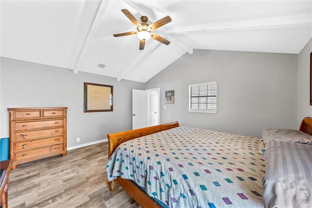 bedroom featuring lofted ceiling with beams, a ceiling fan, baseboards, wood finished floors, and visible vents