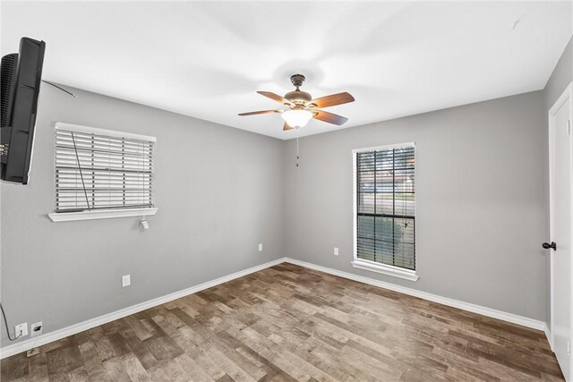 spare room featuring baseboards, a ceiling fan, and wood finished floors