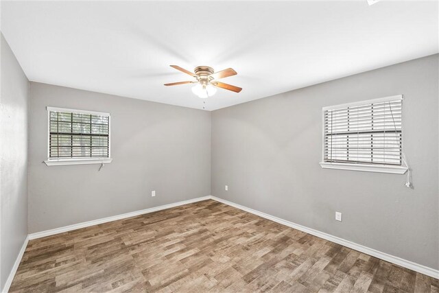 unfurnished room featuring baseboards, a ceiling fan, and wood finished floors