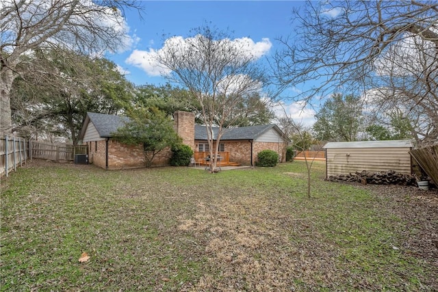 view of yard with an outdoor structure, a storage shed, and a fenced backyard