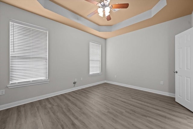 187 Ashland Dr, Woodway, TX 76712 - spare room with baseboards, ceiling fan, a tray ceiling, and wood finished floors