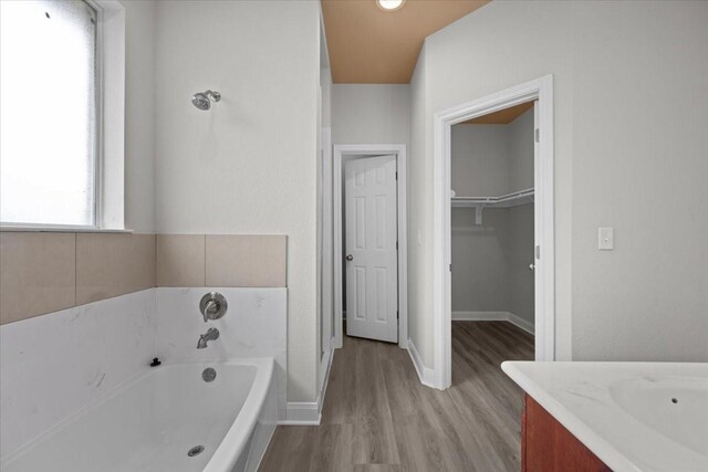 187 Ashland Dr, Woodway, TX 76712 - bathroom with vanity, baseboards, wood finished floors, a spacious closet, and a bath