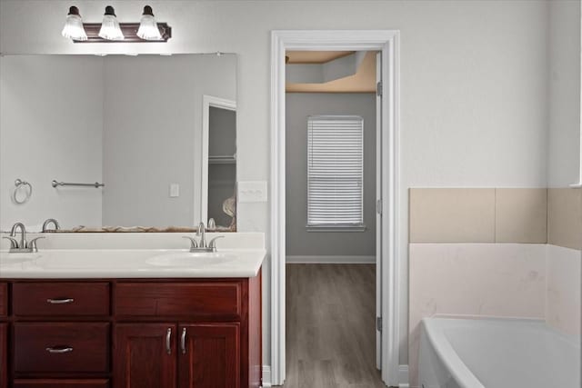 187 Ashland Dr, Woodway, TX 76712 - bathroom featuring wood finished floors, a garden tub, and vanity