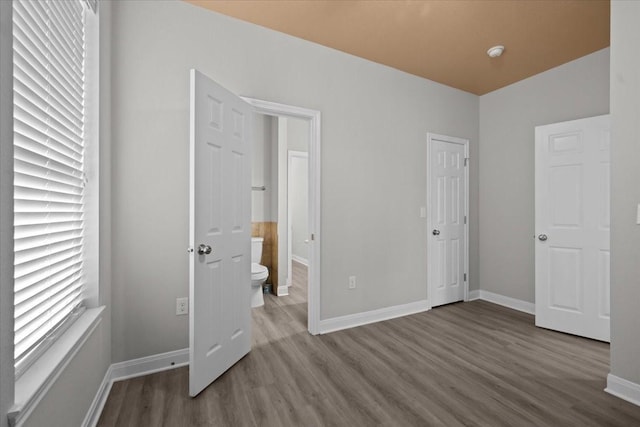 187 Ashland Dr, Woodway, TX 76712 - unfurnished bedroom with baseboards, connected bathroom, and wood finished floors