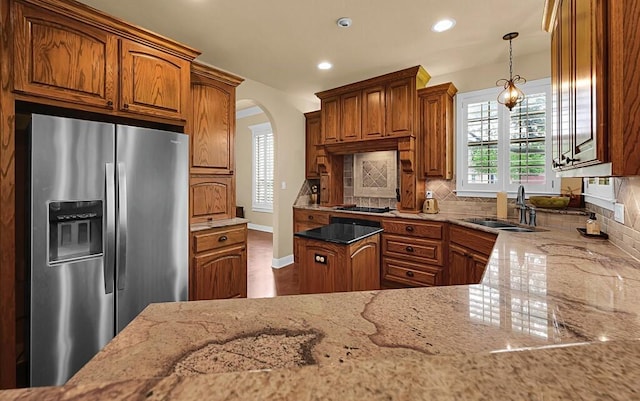 304 Chamberly Rd, Waco, TX 76712 - kitchen featuring light stone counters, brown cabinets, and stainless steel refrigerator with ice dispenser