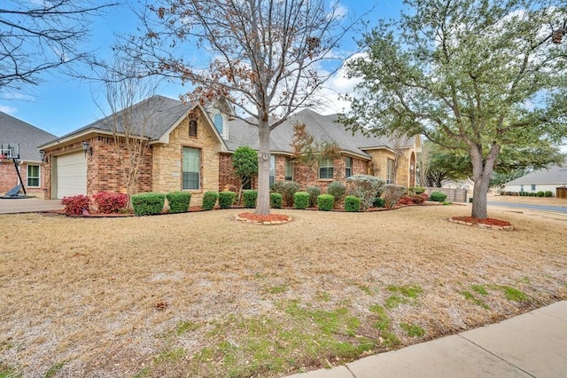 304 Chamberly Rd, Waco, TX 76712 - view of front of home with driveway, a front lawn, stone siding, and a garage