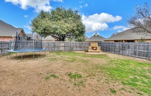 304 Chamberly Rd, Waco, TX 76712 - view of yard with an outdoor stone fireplace, a fenced backyard, and a trampoline