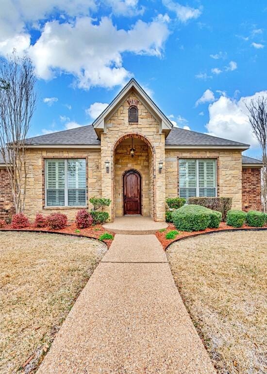 304 Chamberly Rd, Waco, TX 76712 - view of front of property with a shingled roof, a front yard, and stone siding