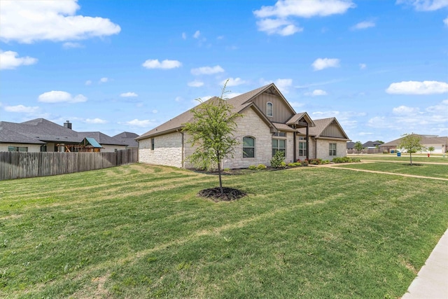 view of front of property with a residential view, stone siding, fence, board and batten siding, and a front yard