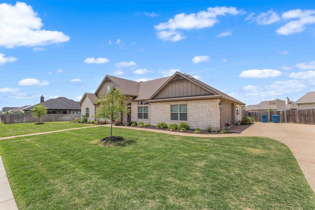 view of front facade with driveway, fence, board and batten siding, and a front yard