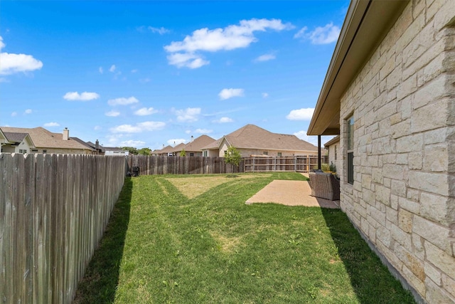 view of yard with a fenced backyard, a residential view, and a patio