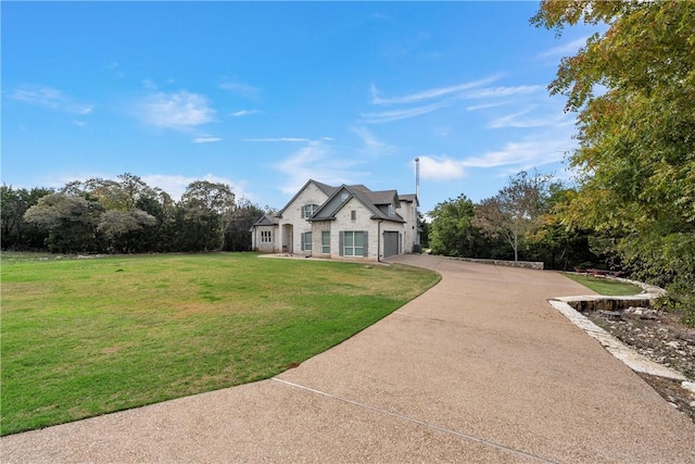 french country home featuring a garage, a front yard, and driveway