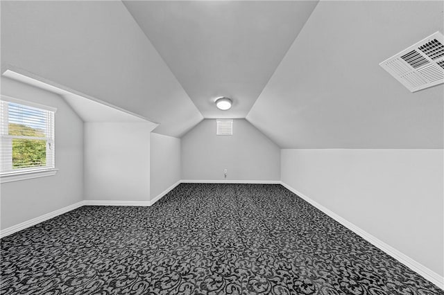 additional living space with baseboards, visible vents, and carpet floors