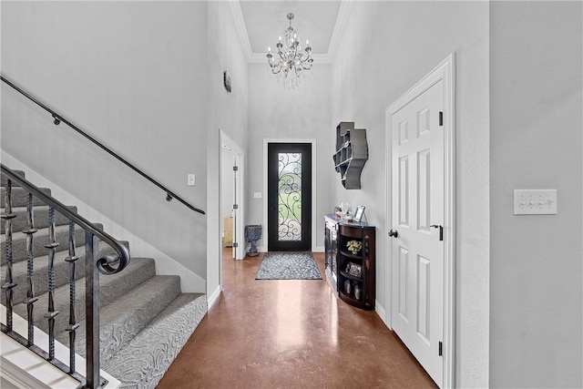 foyer entrance featuring stairway, baseboards, concrete flooring, a towering ceiling, and a notable chandelier