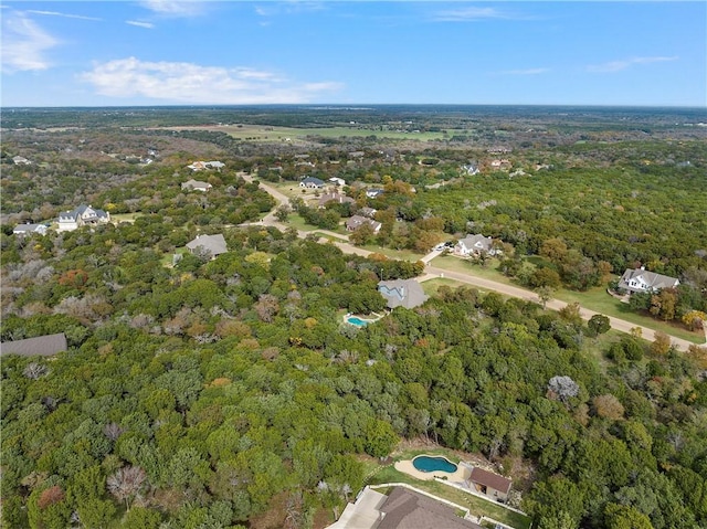 drone / aerial view featuring a wooded view