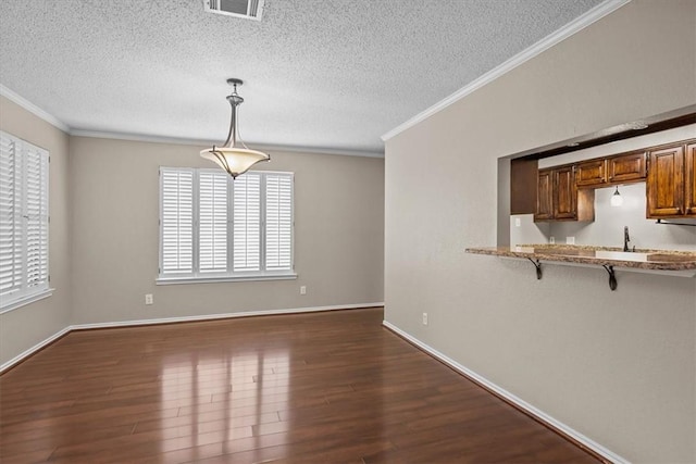 102 Pleasant Grove Ln Unit 102, Waco, TX 76712 - unfurnished dining area featuring visible vents, a textured ceiling, dark wood-style flooring, and crown molding