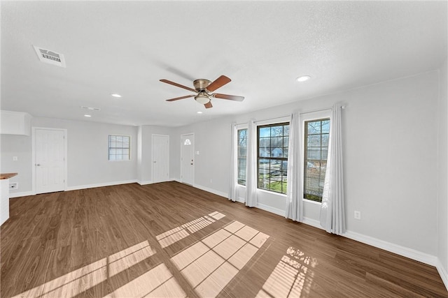 unfurnished living room with a ceiling fan, recessed lighting, baseboards, and dark wood-type flooring