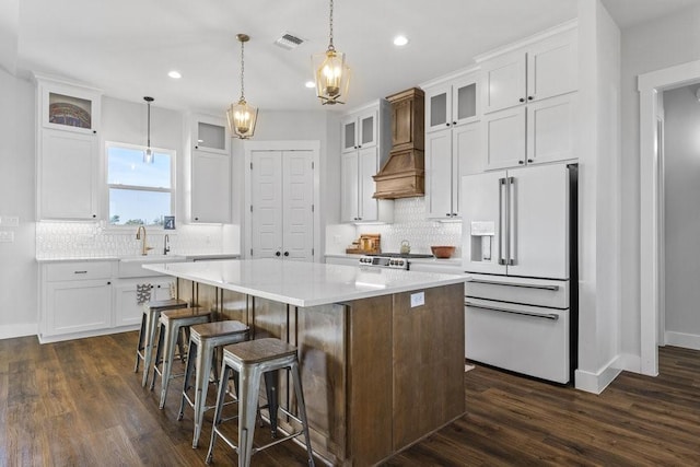 1215 Ropers Alley Rd, Belton, TX 76513 - kitchen featuring visible vents, custom range hood, a center island, high end white fridge, and white cabinets